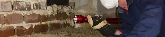 Pest control technician inspecting a crawl space for ant activity and entry points in Tucson, AZ