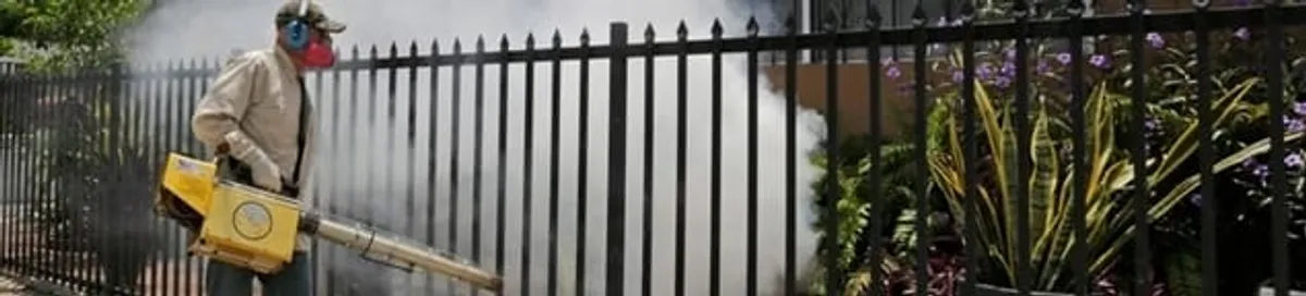 Mosquito control technician fogging a yard perimeter for mosquito reduction in Tucson, AZ